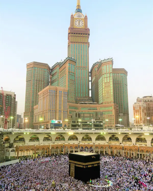 Pilgrims around the Kaaba with the Makkah clock tower behind